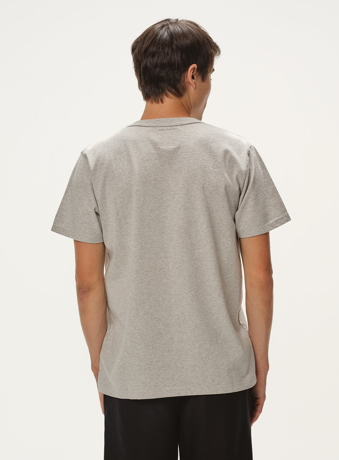 Model wearing a light grey t-shirt, back view, showcasing the plain back of the shirt.
