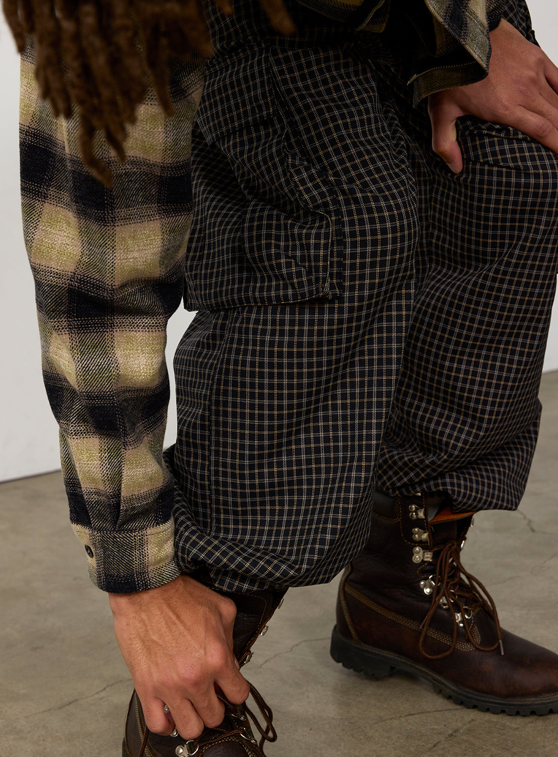 Relaxed-fit dark checkered Pattern 6-Pocket Pants by BEAMS with large side pockets, worn with a plaid flannel shirt and brown leather hiking boots.
