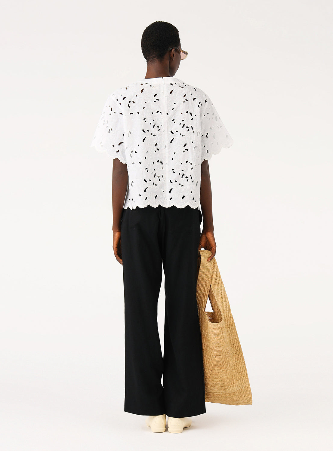 Back view of a model in a white blouse, highlighting the simple silhouette and effortless comfort.