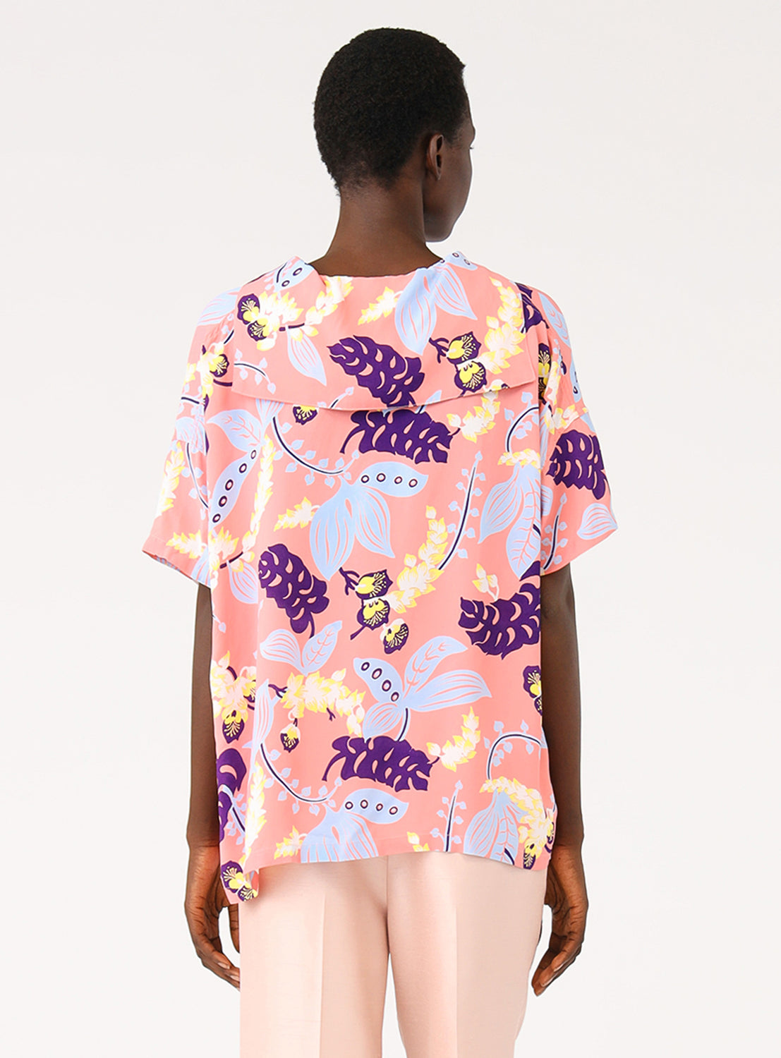 Back view of a model in the pink patterned shirt, showing the full design and fit.
