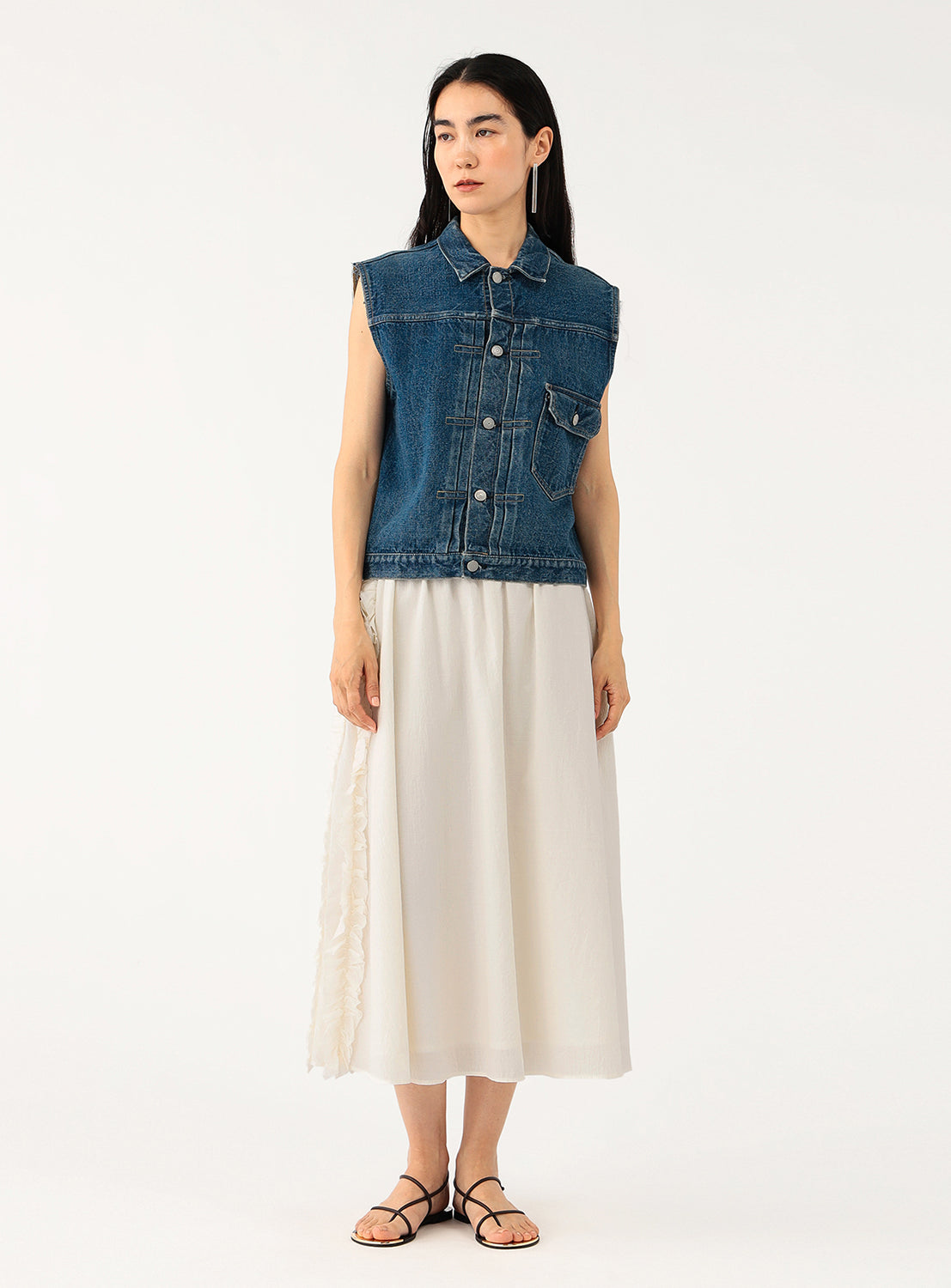 Full body shot of a model wearing a white crinkle-textured midi skirt.