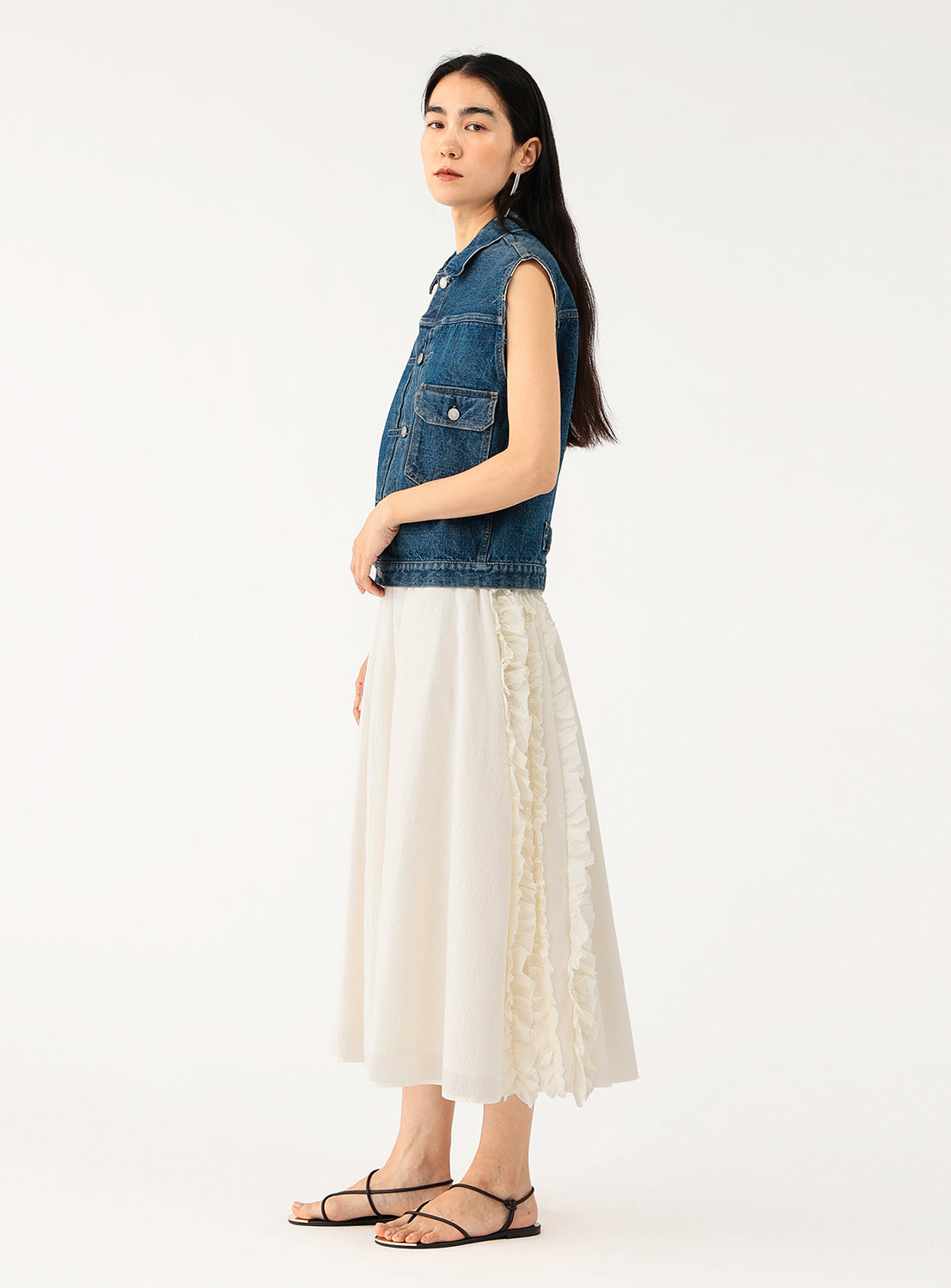 Side view of a model in the white skirt, highlighting the flow and tiered ruffle detail.