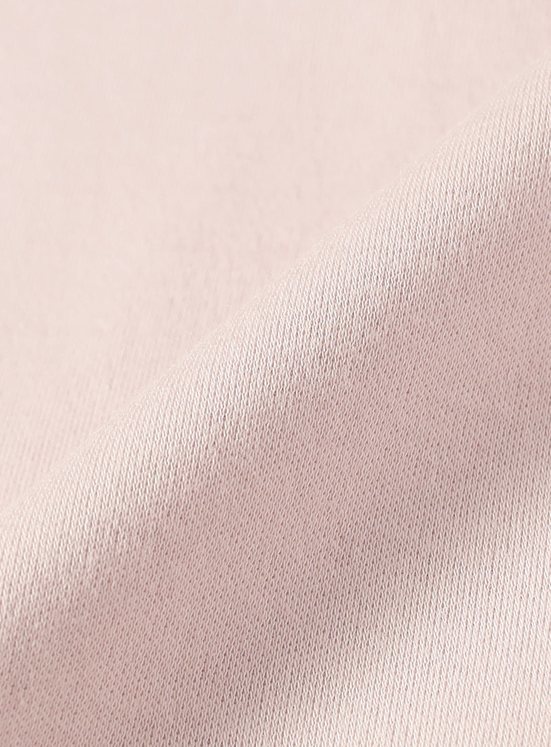 Close-up of the light pink material, highlighting the fabric quality of the cotton.