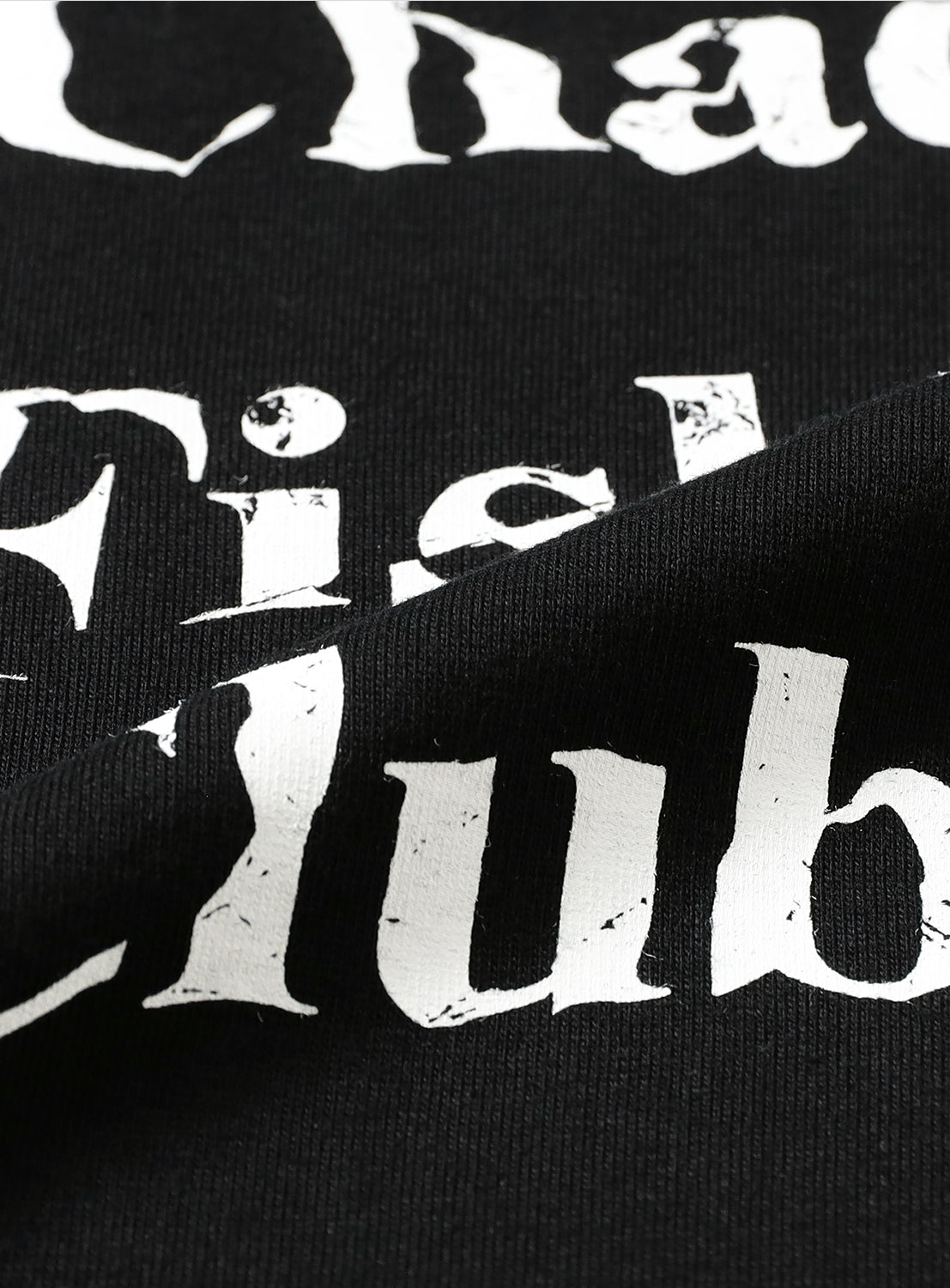 Close-up of black t-shirt fabric, detailing the white "Chaos Fishing Club" graphic print.