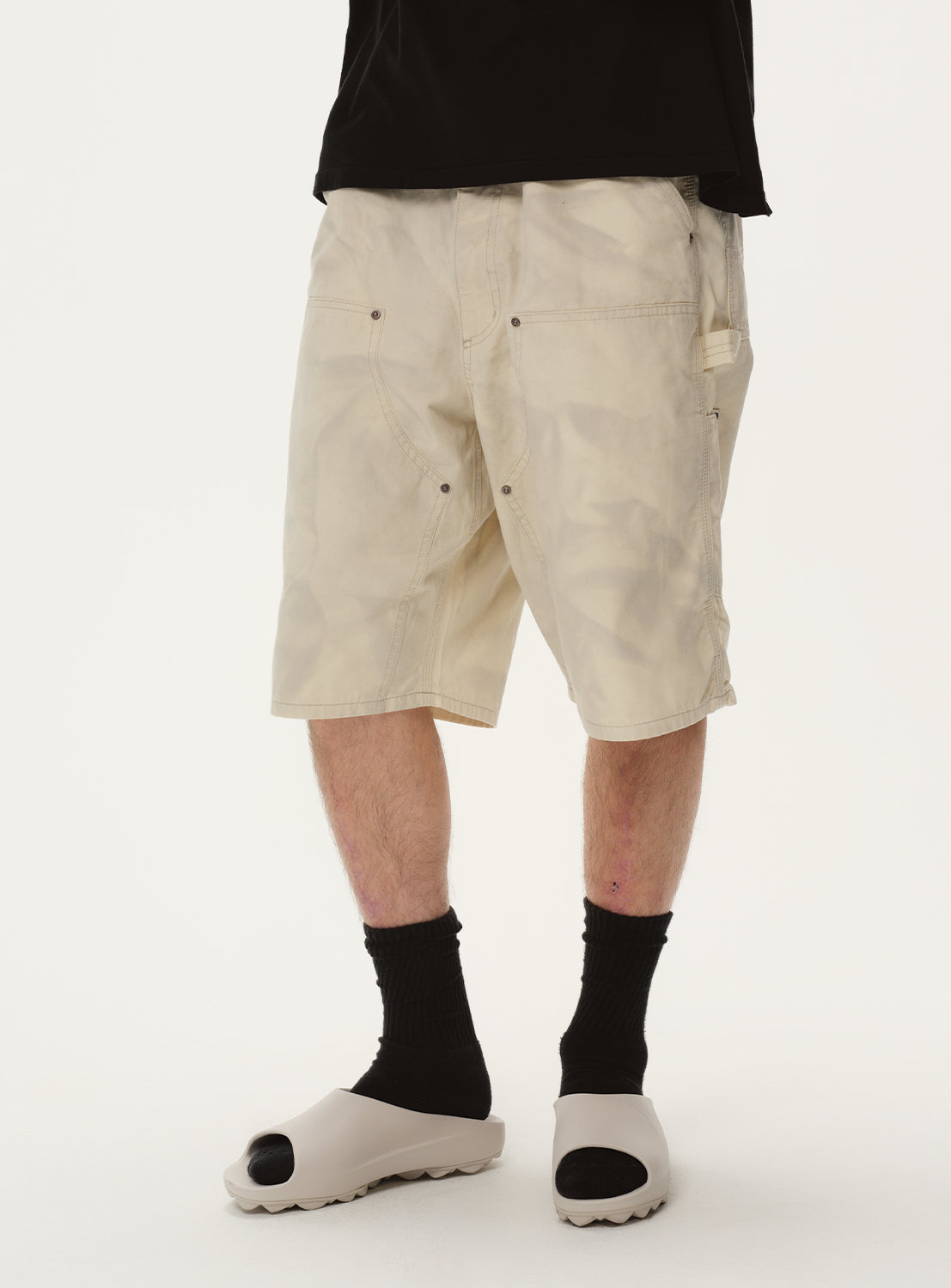 Close-up of a model wearing off-white shorts, focusing on the leg length and styling.
