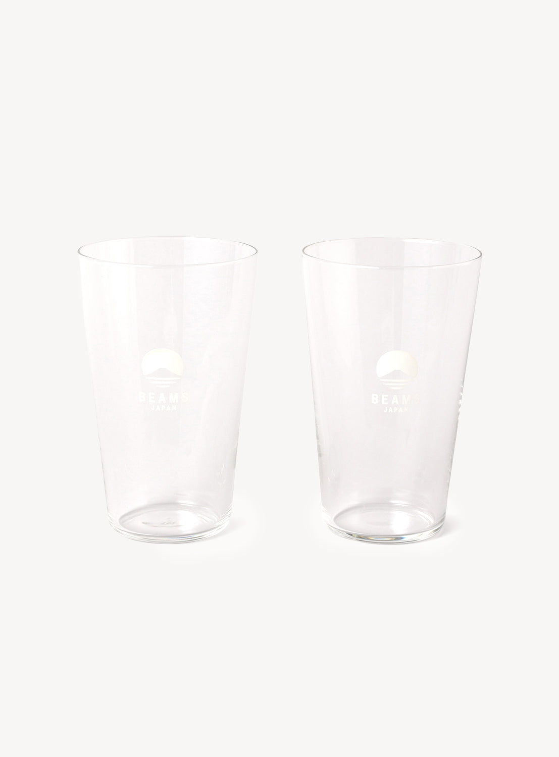 Two clear glass tumblers on a white background