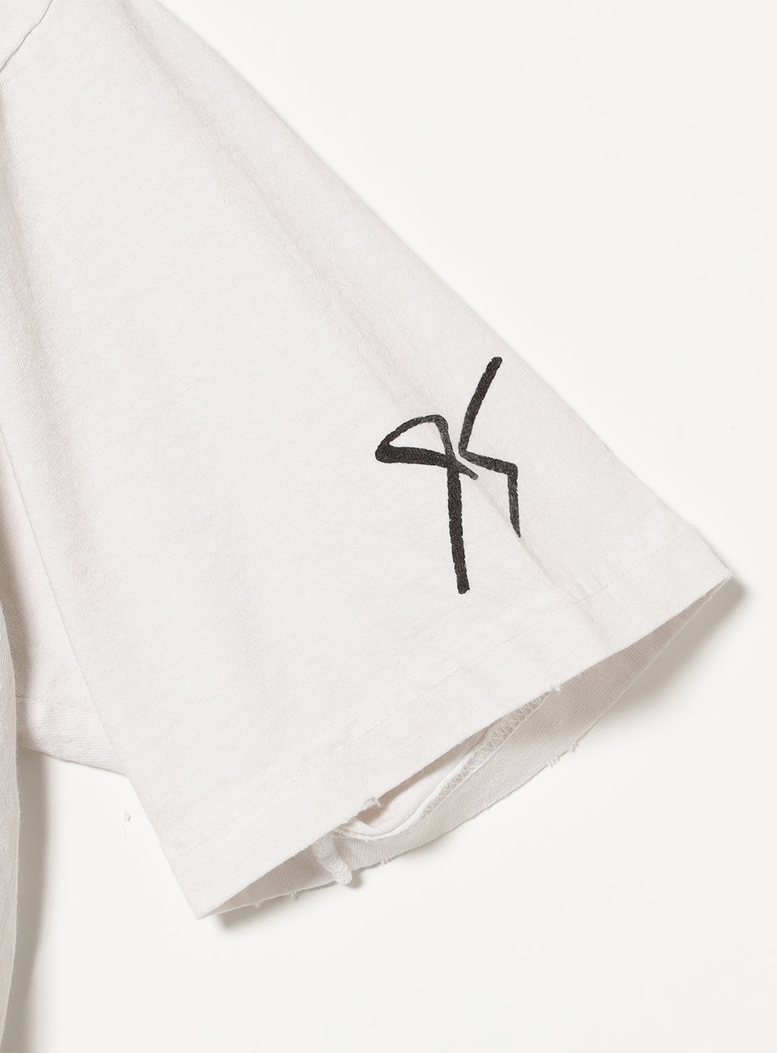 Tee sleeve detail showing a subtle stylized graphic, enhanced by the garment wash.