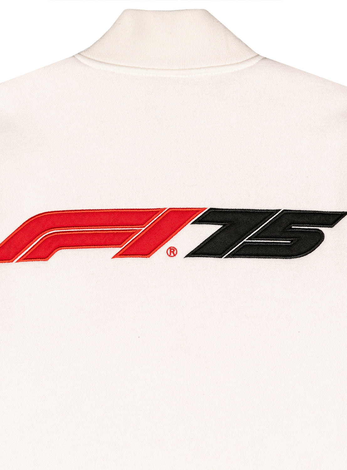 Close up of the embroidered F1 75 year logo on the white varsity jacket. 