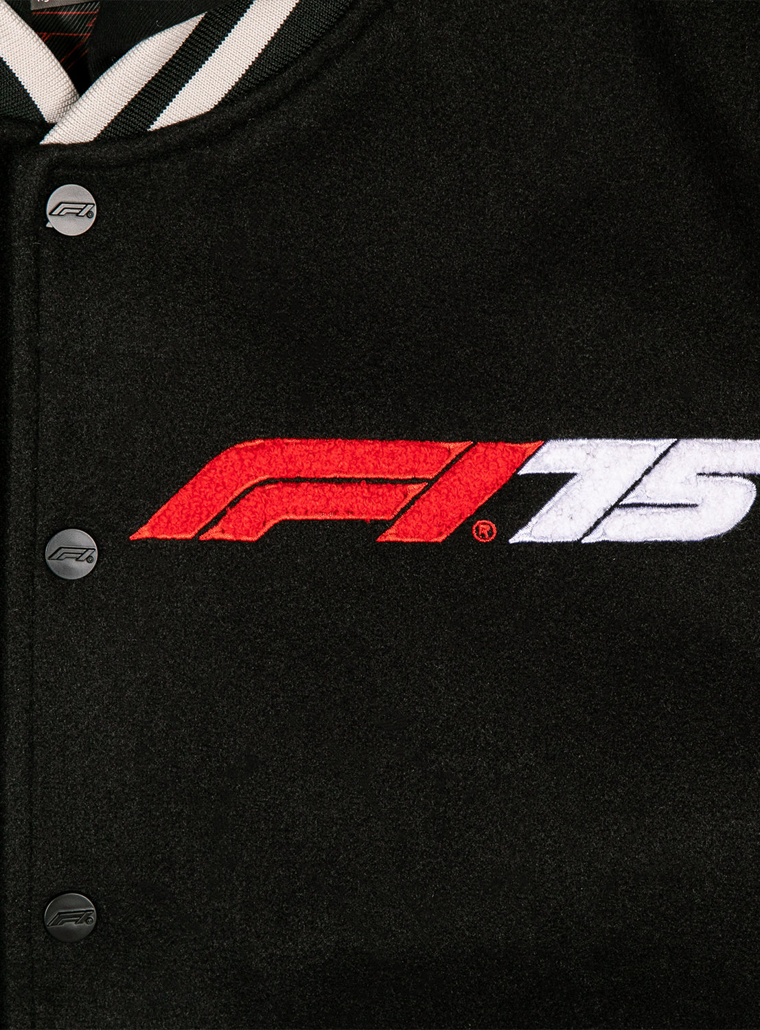 Close up of the embroidered F1 75 logo and button details. 
