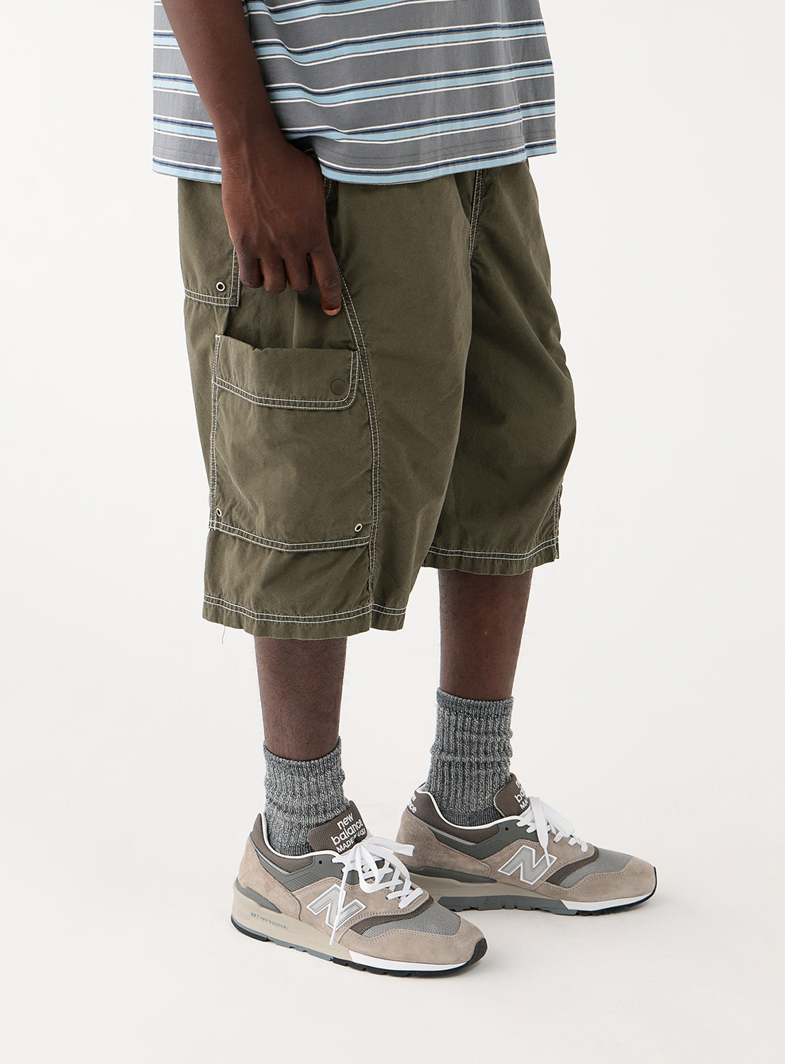 Close-up of a model wearing the olive green shorts, focusing on the leg length and pocket detail.
