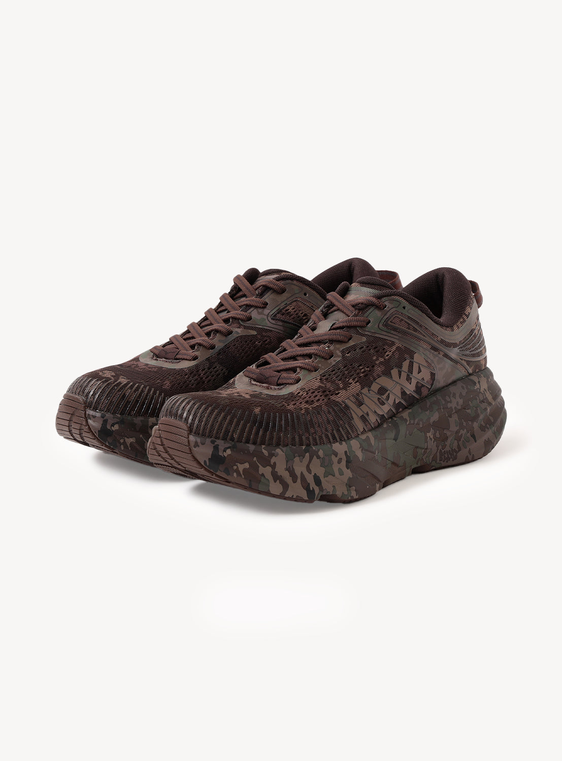 A pair of Hoka U BONDI 7 BEAMS sneakers in a brown and green camo pattern, featuring thick soles with lightweight cushioning and an engineered mesh upper, displayed from a front angle on a white background.