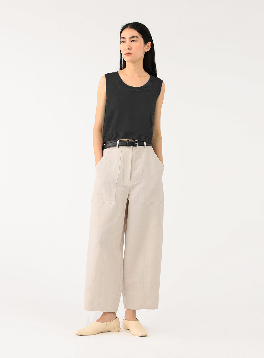 Full body shot of a model wearing oyster-colored cropped pants.
