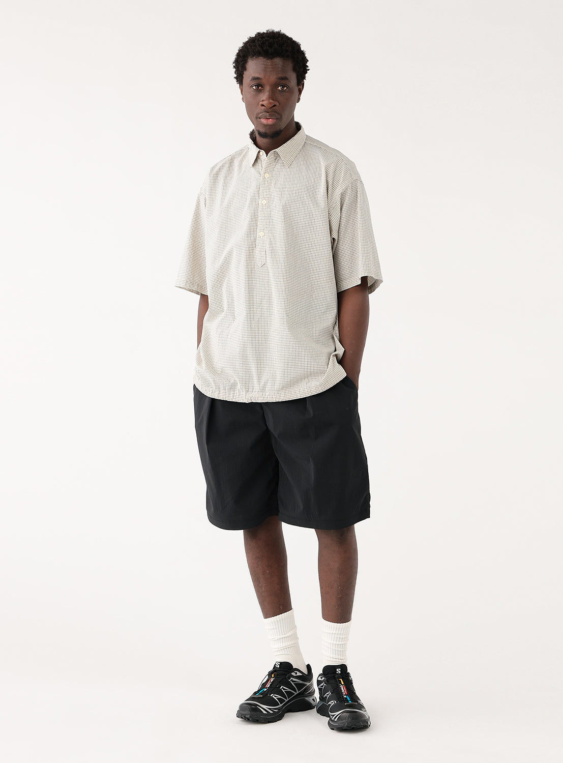 Model in off-white check-patterned pullover shirt, front view, displaying balanced silhouette and versatile design.