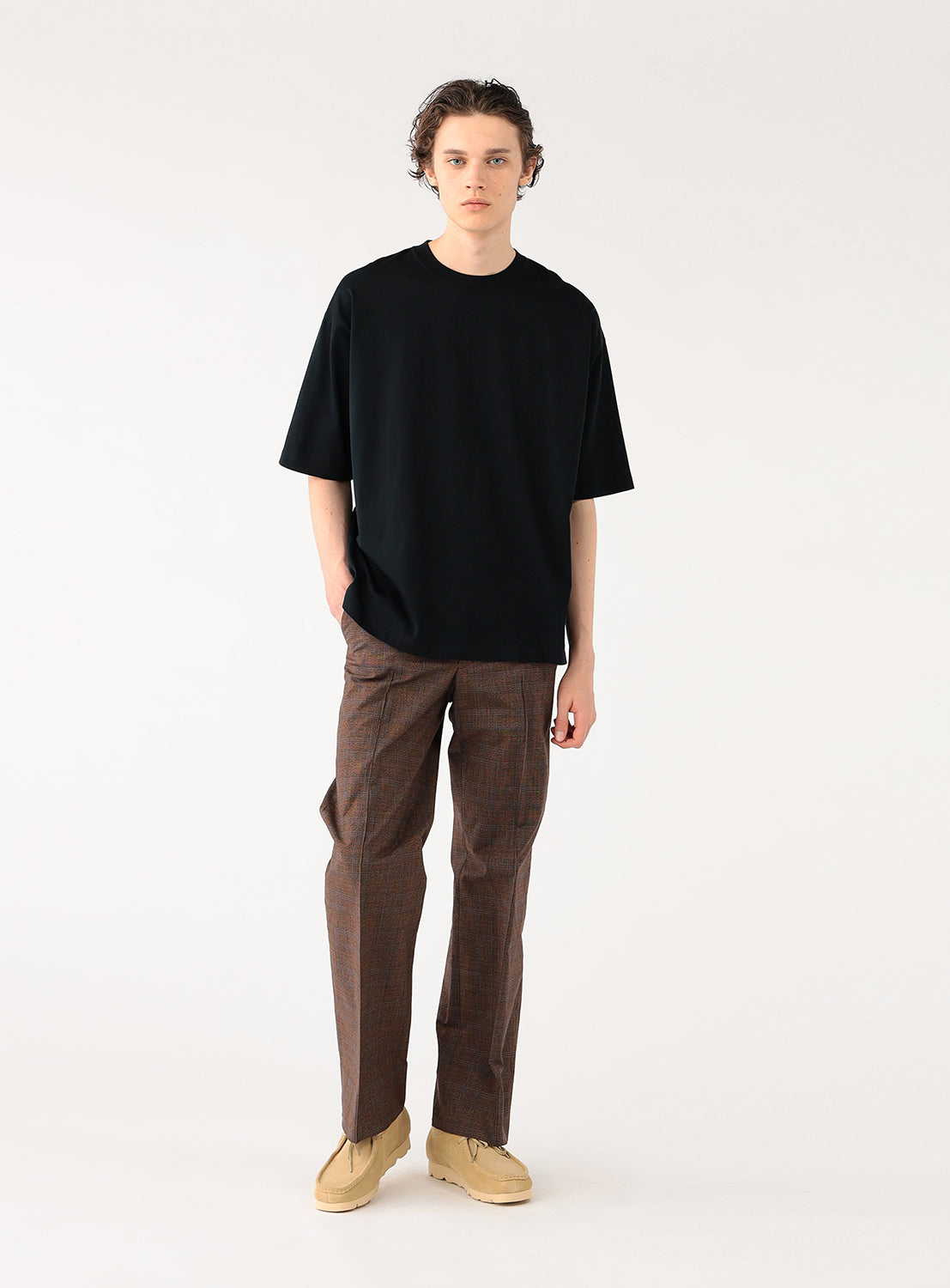Model wearing a black t-shirt and brown pants