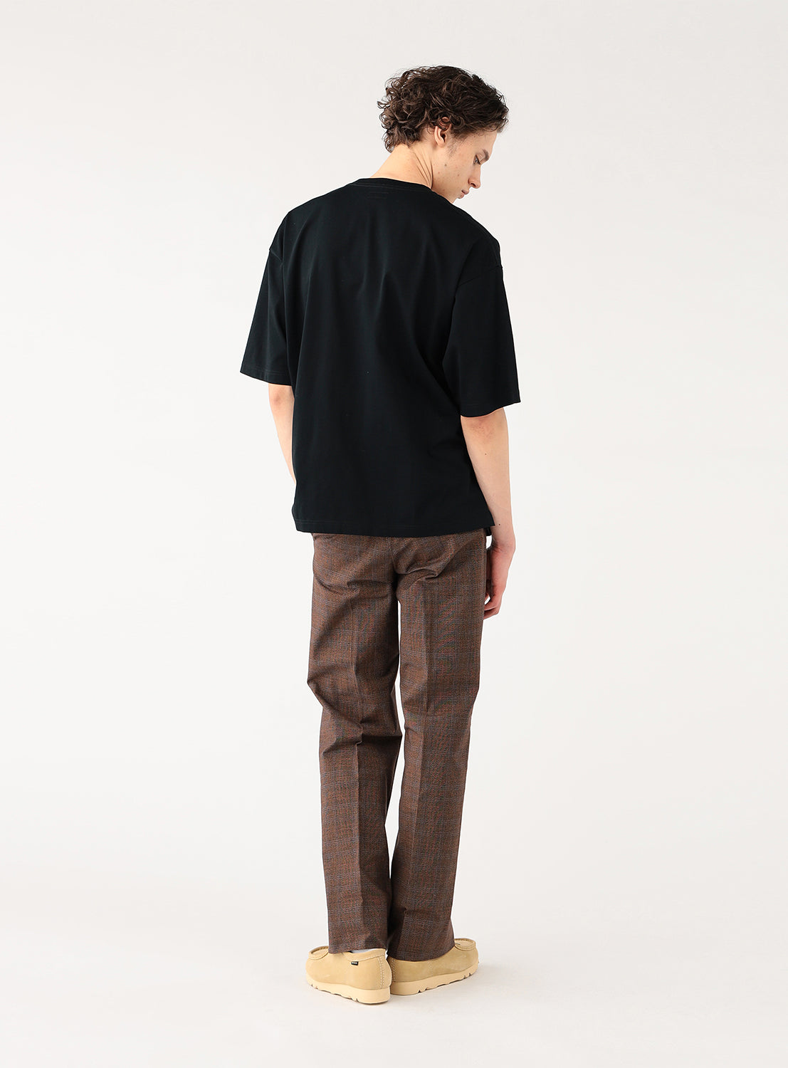 Back view of model wearing a black cotton tshirt