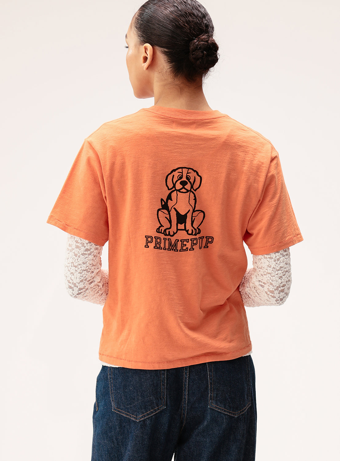Person wearing an orange t-shirt with a dog graphic and 'PRIMEUP' text on the back.
