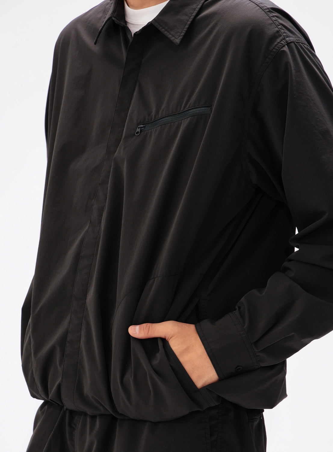 BEAMS Tech Shirt in black, featuring a collared long-sleeve design with a zippered chest pocket and side pockets.