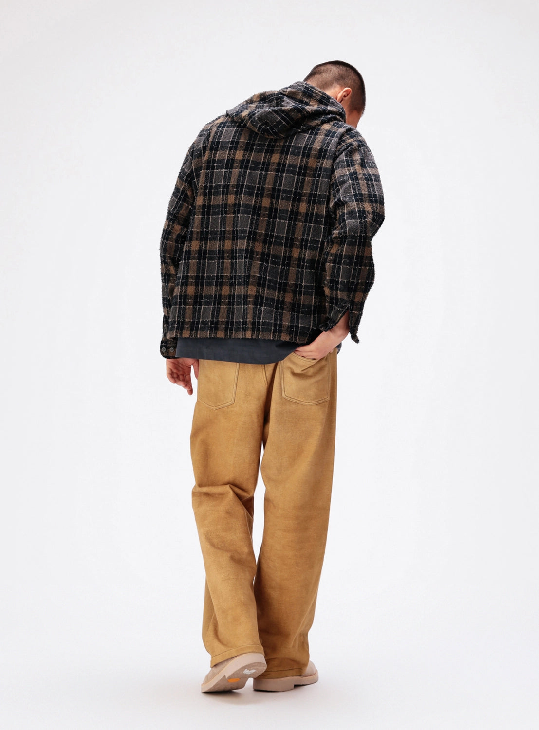 A person seen from behind wearing a BEAMS Bouclé Flannel Hooded Shirt over a dark gray t-shirt, tan trousers, and light-colored shoes.