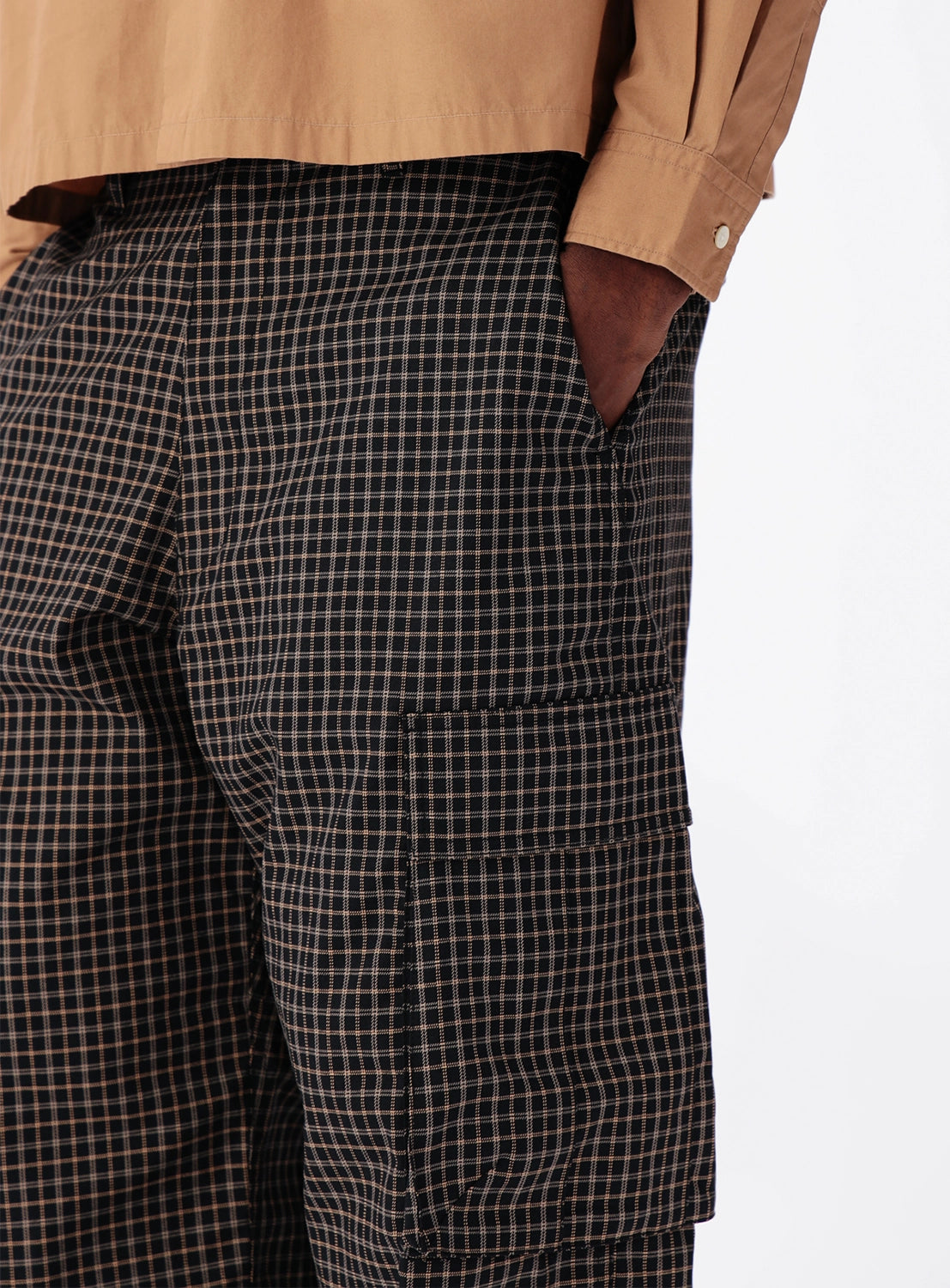 BEAMS Pattern 6-Pocket Pants in a relaxed-fit checkered style featuring a side pocket and adjustable hems, worn with a tan button-down shirt.
