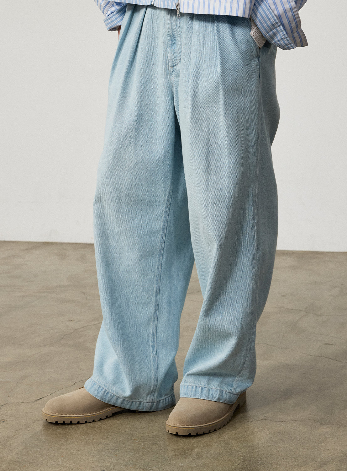 BEAMS Wide Denim Slacks in a light-wash, pleated, wide-leg fit, styled with tan suede shoes.