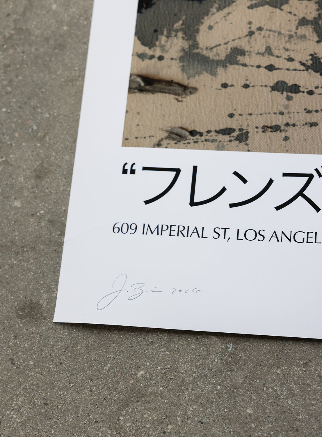 Here’s a rewritten sentence using the provided product data: The J. BRIAN x BEAMS POSTER 1 by BEAMS AMERICA rests in the corner on a concrete floor, displaying Japanese text, 609 IMPERIAL ST, LOS ANGELES, and a handwritten signature with 2024 at the bottom. Featuring Jereme Brian Mendez’s artwork for BEAMS AMERICA’s special 50th anniversary edition, the main image of the poster is partially visible at the top.