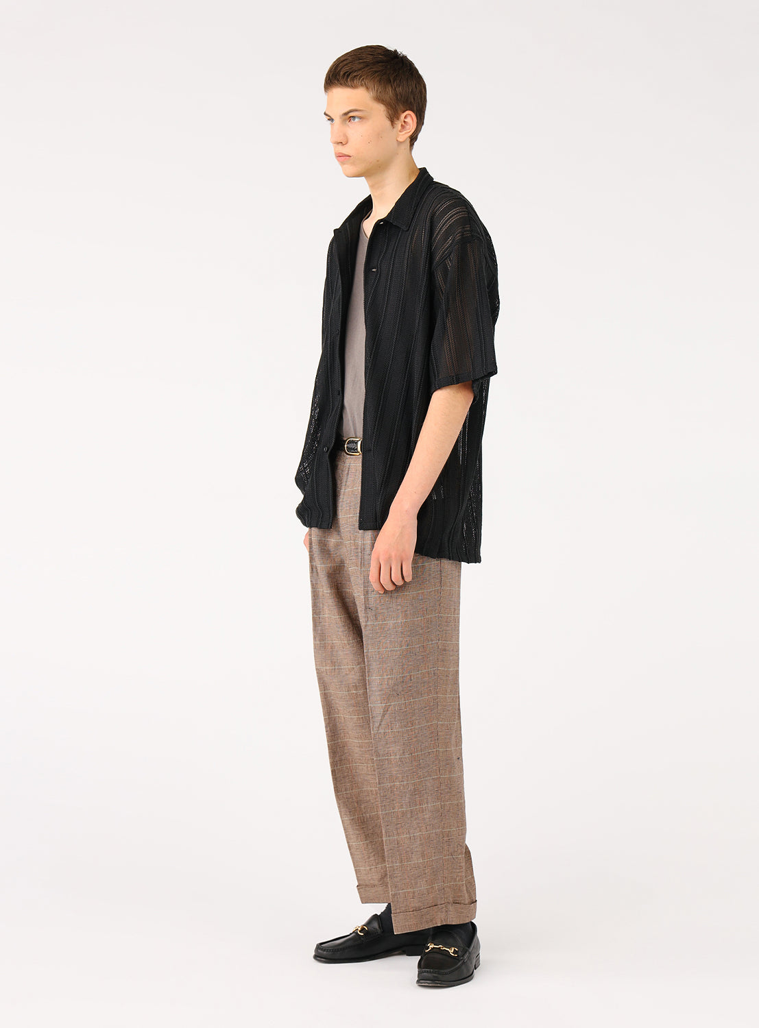 Side view of a model in the mesh shirt, showcasing the elasticated cuffs and subtle sleeve volume.