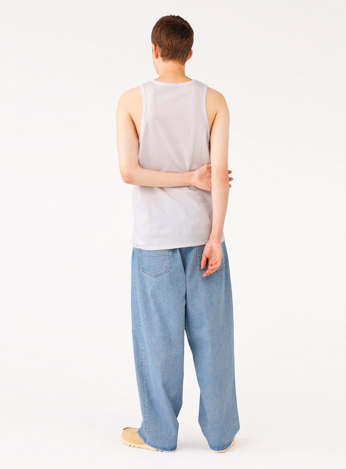 Back view of a model in the white ribbed tank top, showing the full design and fit.