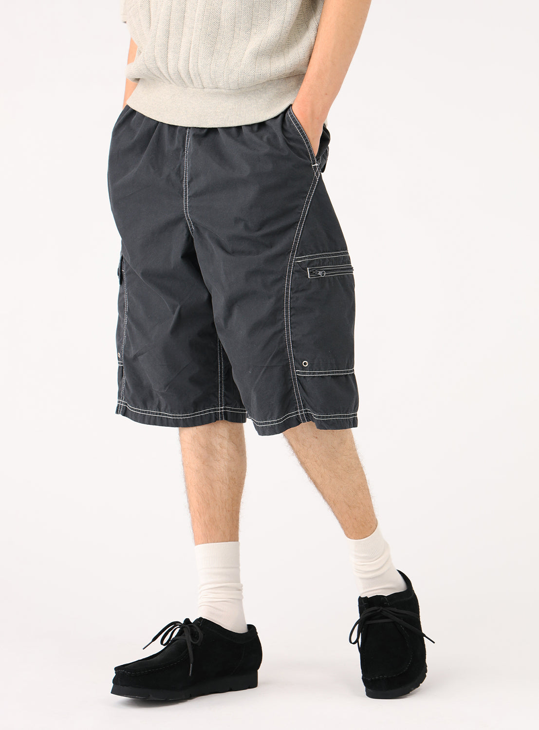 Side view of a model in the black shorts, highlighting the side pocket and contrast stitching.