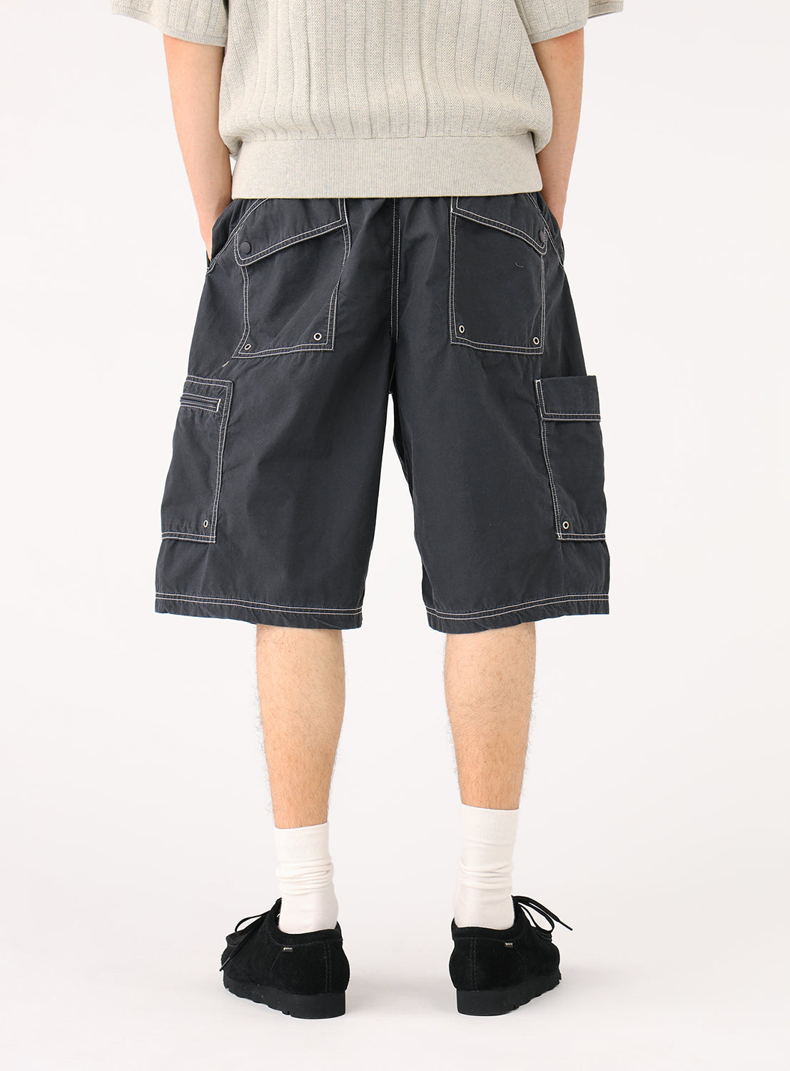 Back view of a model in the black shorts, highlighting the back pockets and contrast stitching.