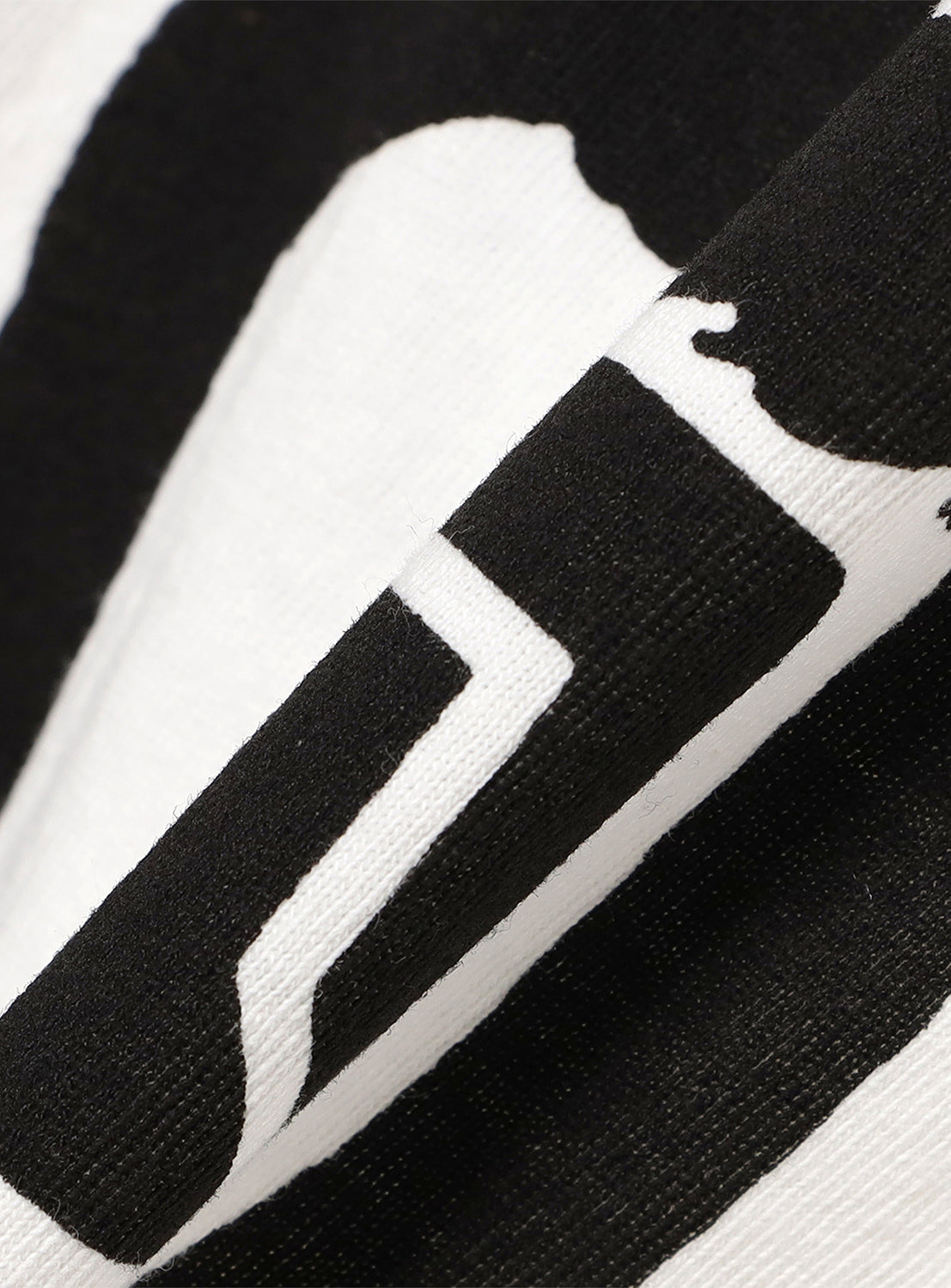 Close-up of white t-shirt fabric, detailing the black stylized head graphic and "Tacoma Fuji Records" text.