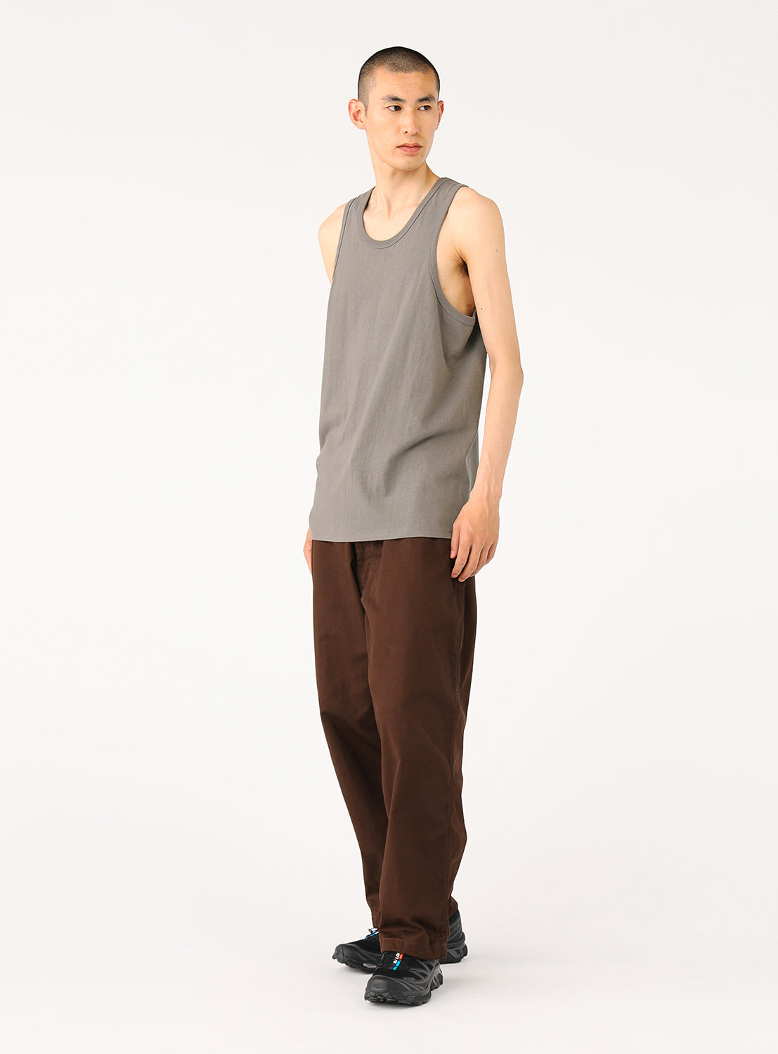 Side view of a model in the grey tank top, highlighting the fit and relaxed silhouette.