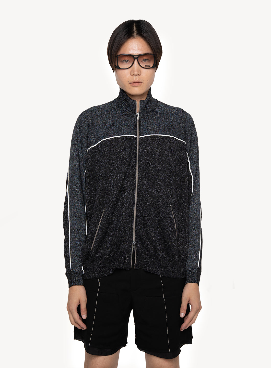 A person with straight dark hair and large dark glasses is wearing the DAIRIKU Jersey Knit Training Jacket with white piping and black shorts, standing against a plain white background.