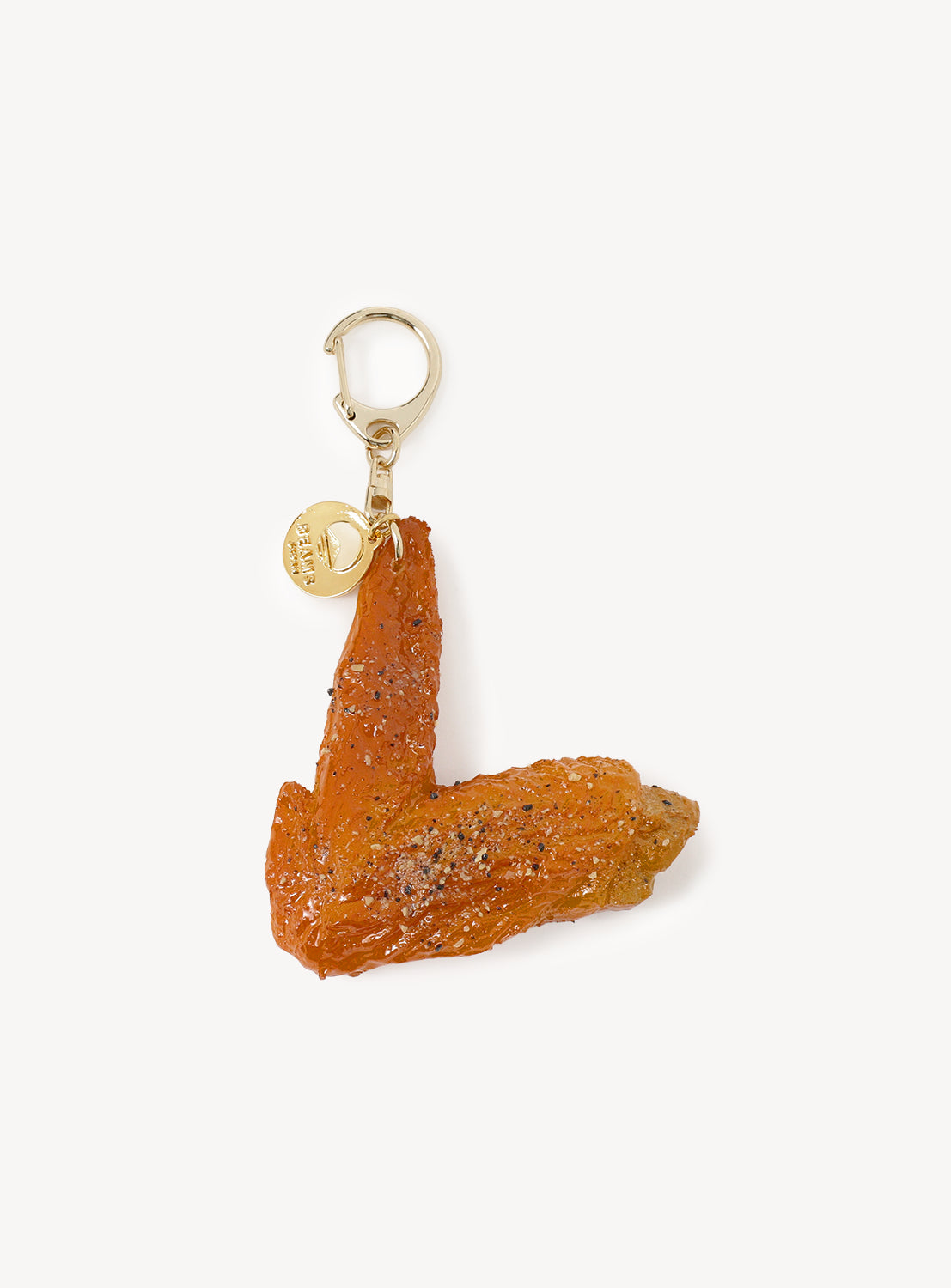 The [Exclusive] BEAMS JAPAN Sample Kobo Realistic Food Sample Keychain - Vol. 1 by SAMPLE KOBO x BEAMS JAPAN features an incredibly realistic, textured chicken wing charm attached to a gold clasp and a small round tag, displayed against a plain white background.