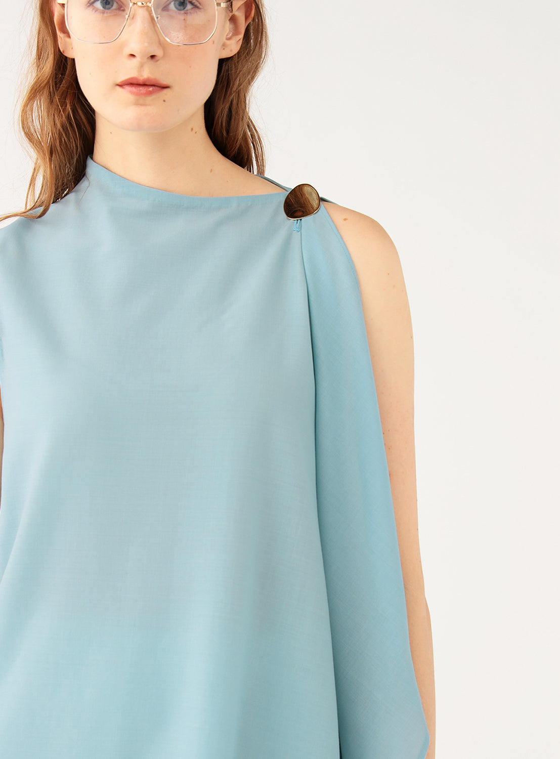 Close up of the gold button closure on the top of the sleeve.
