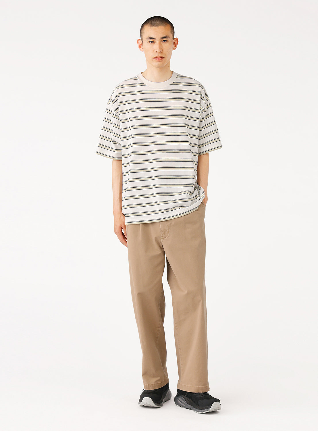 model in the cream striped t-shirt, showing the loose fit and length over pants.