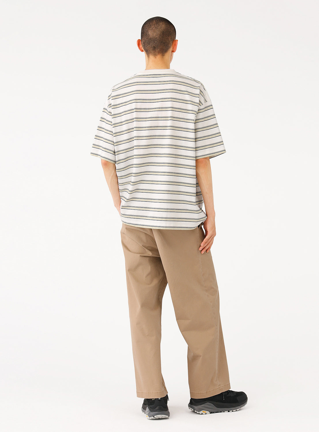 Back view of a model in the cream striped t-shirt, showcasing the relaxed fit from behind.