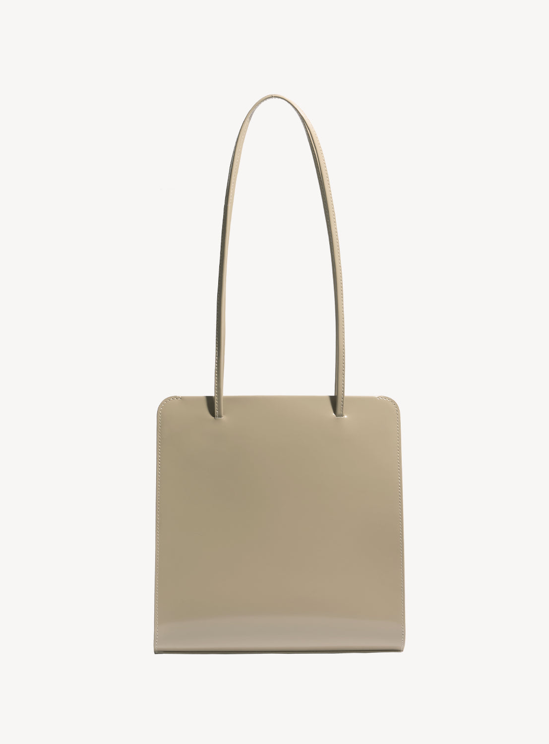 Latte brown square handbag with long, ribbon-like straps.