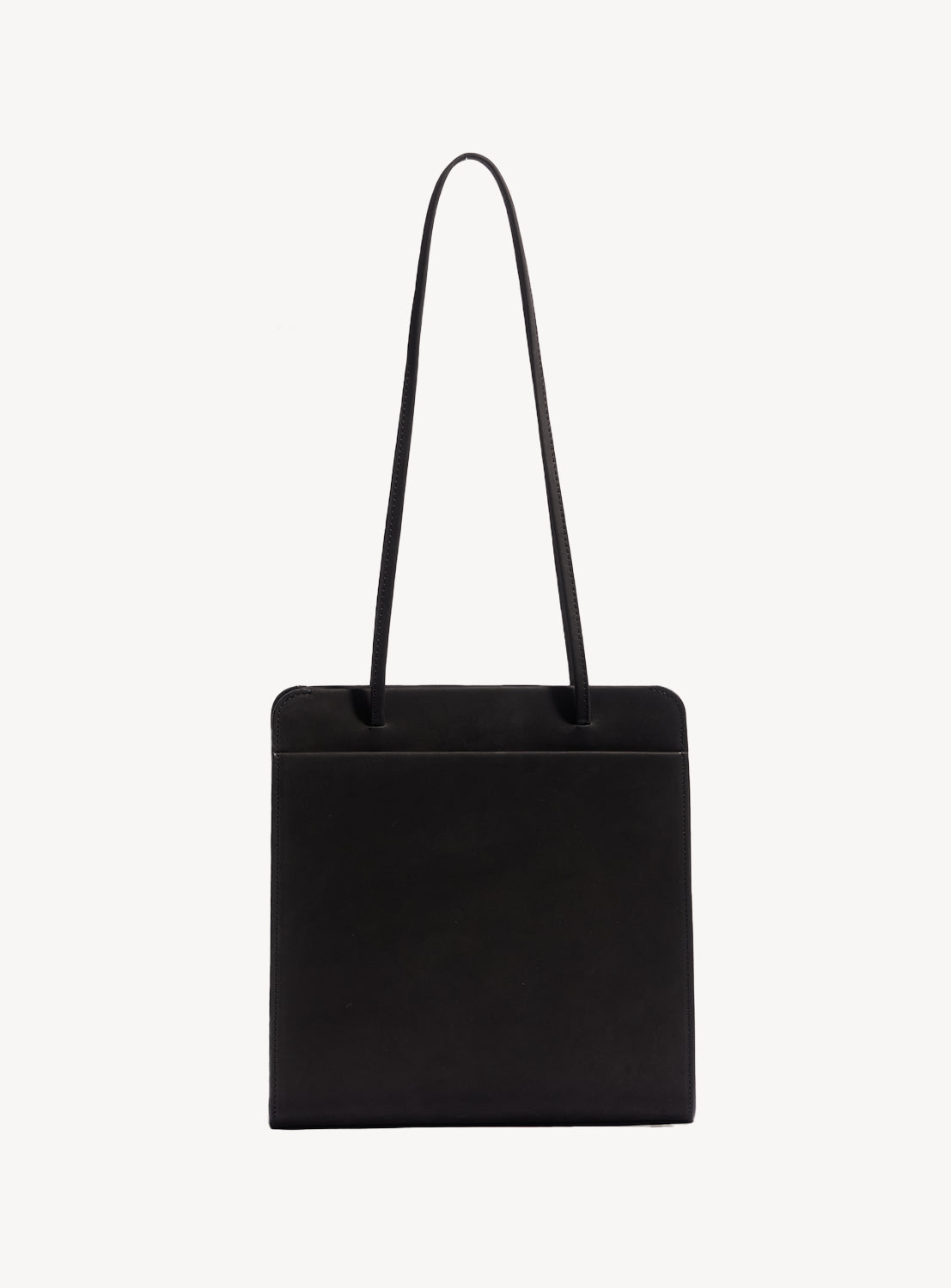 Back of black square handbag with long, ribbon-like straps.