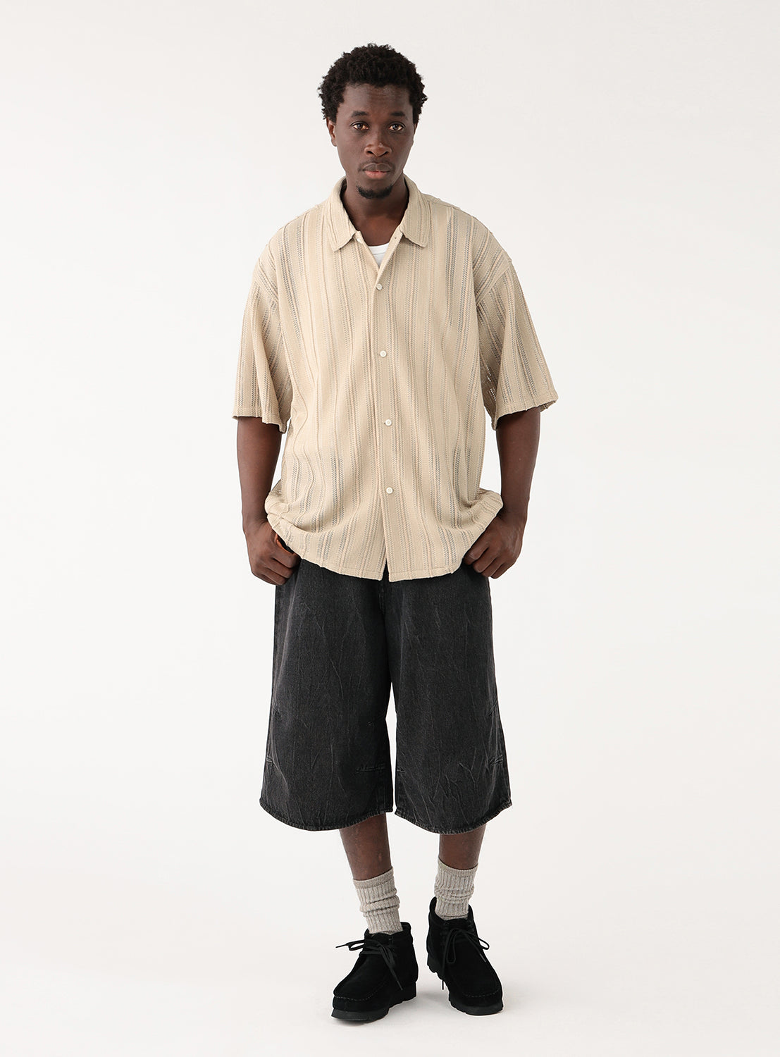 Full body view of a model in the mesh shirt, showcasing the elasticated cuffs and subtle sleeve volume.