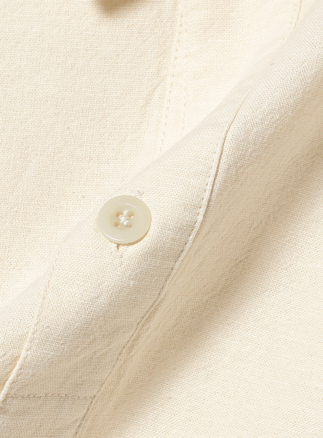 Close-up of natural (beige cream) military pullover shirt fabric and matching button, detailing the soft cotton back satin texture.