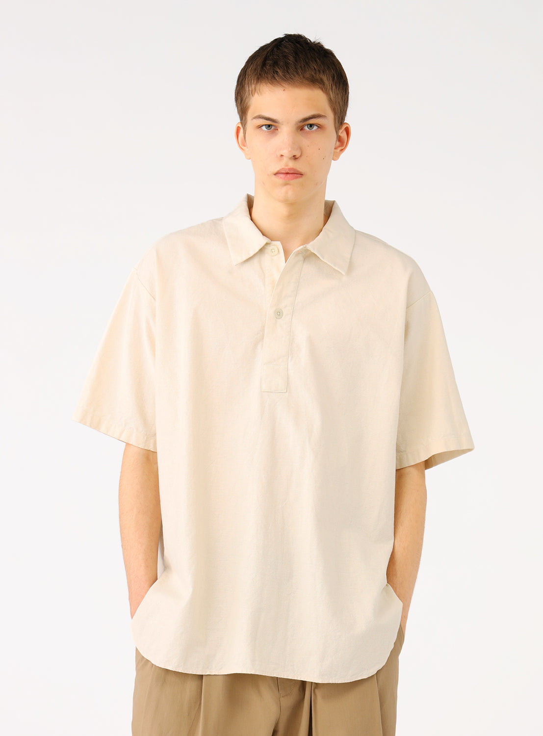 Model wearing a natural (beige cream) military pullover shirt, front view, showcasing its relaxed neckline and dropped shoulders.