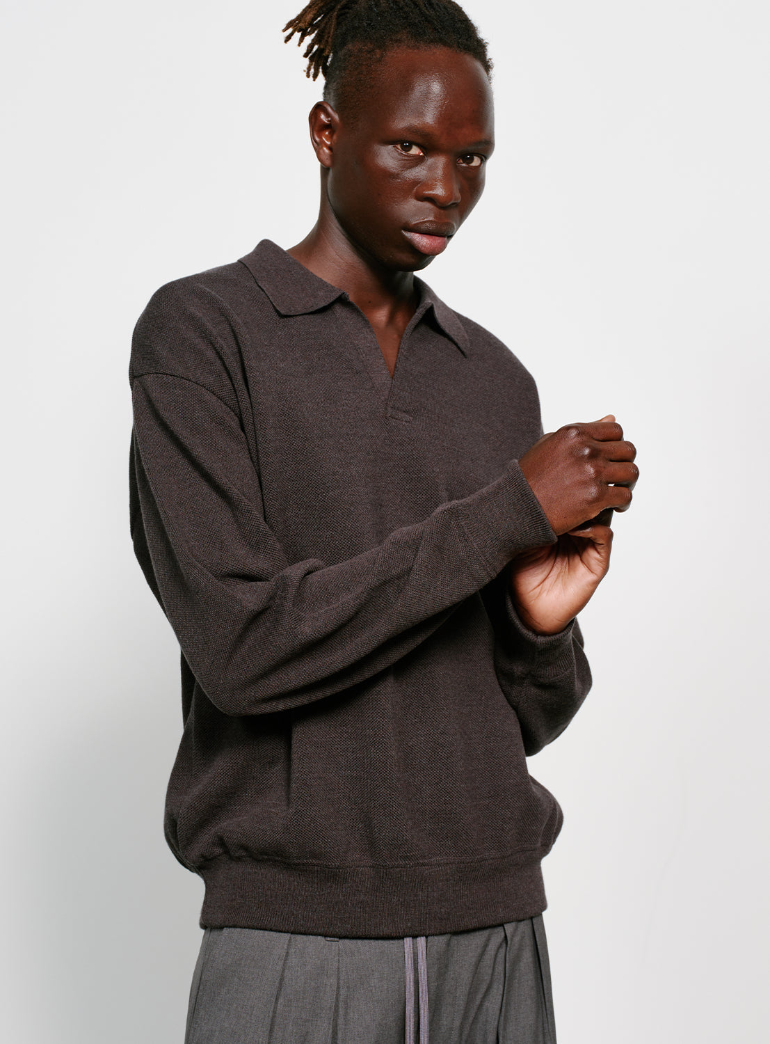 Model wearing a dark gray sweater with a collar on a white background.
