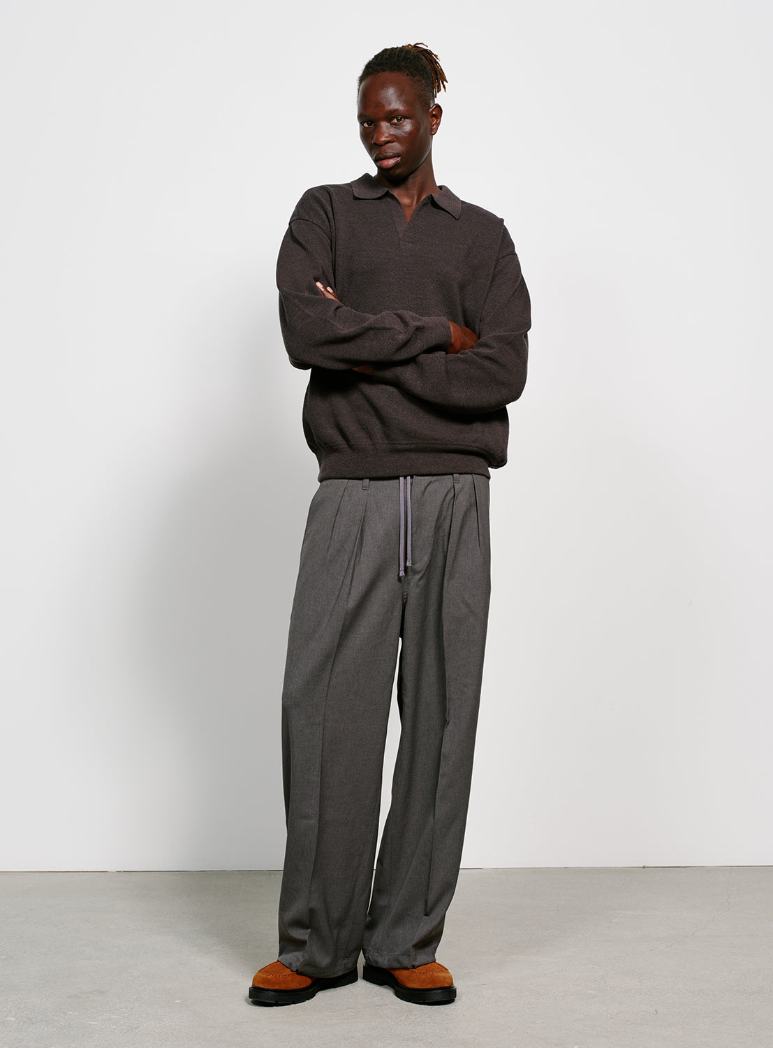 Model wearing a dark gray sweater with a collar on a white background.