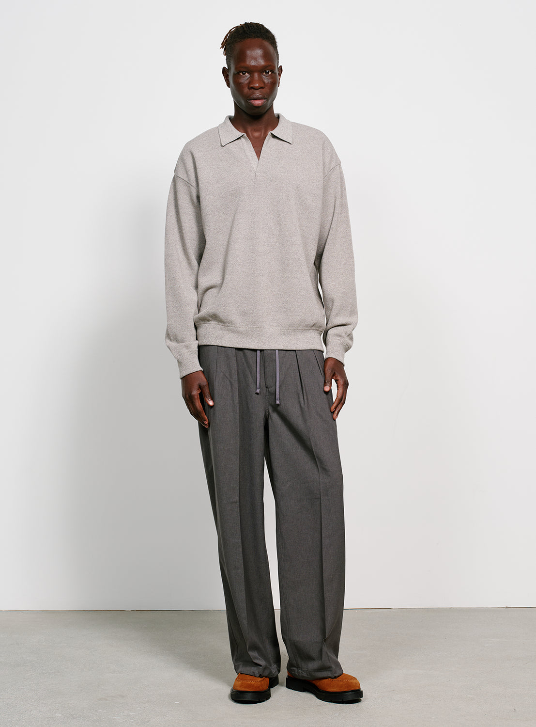 Model wearing a gray sweater with a collar on a white background.