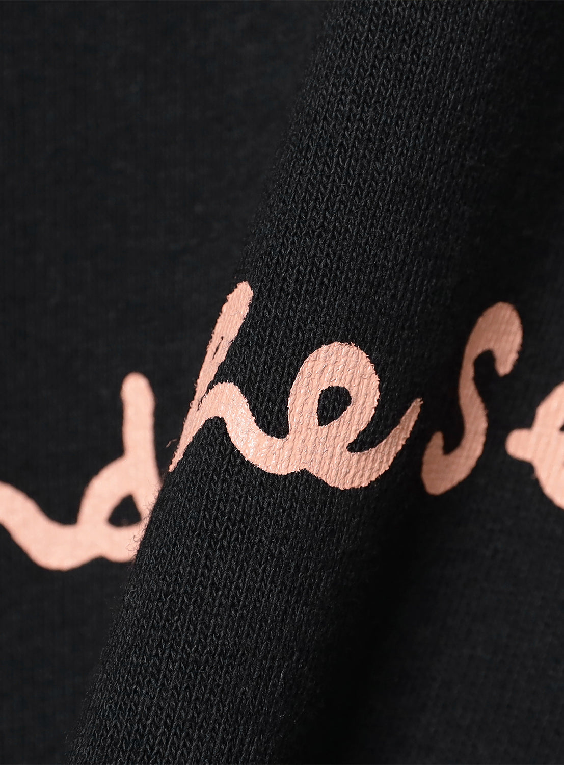 Black fabric with close up of text print. 