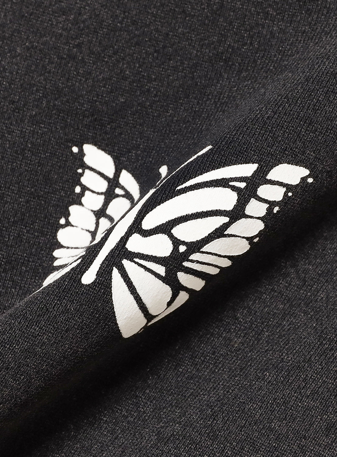 Close up of black fabric with a white butterfly design in white.