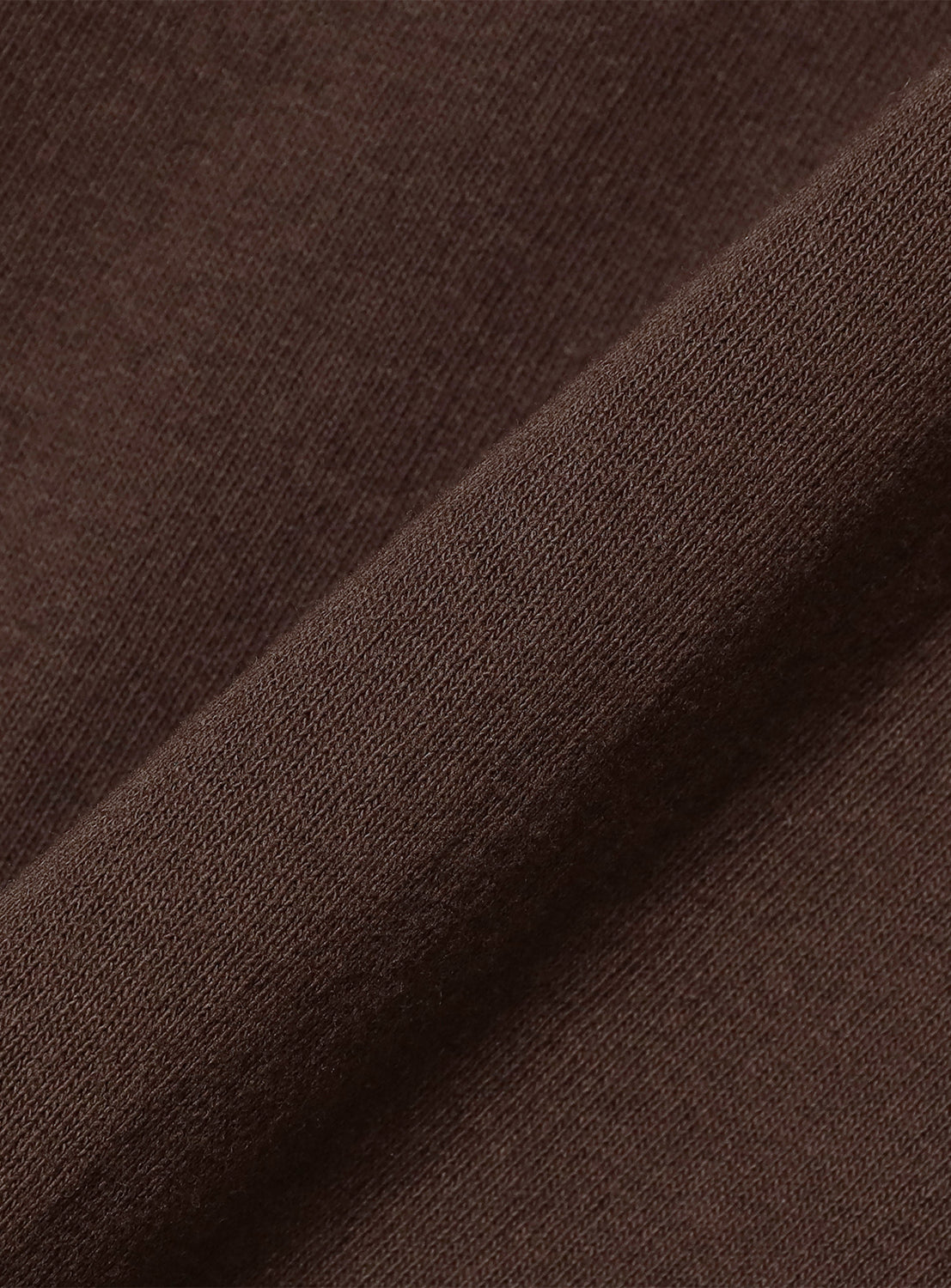 Extreme close-up of the deep dark brown cotton fabric, revealing its soft ribbed texture and quality.