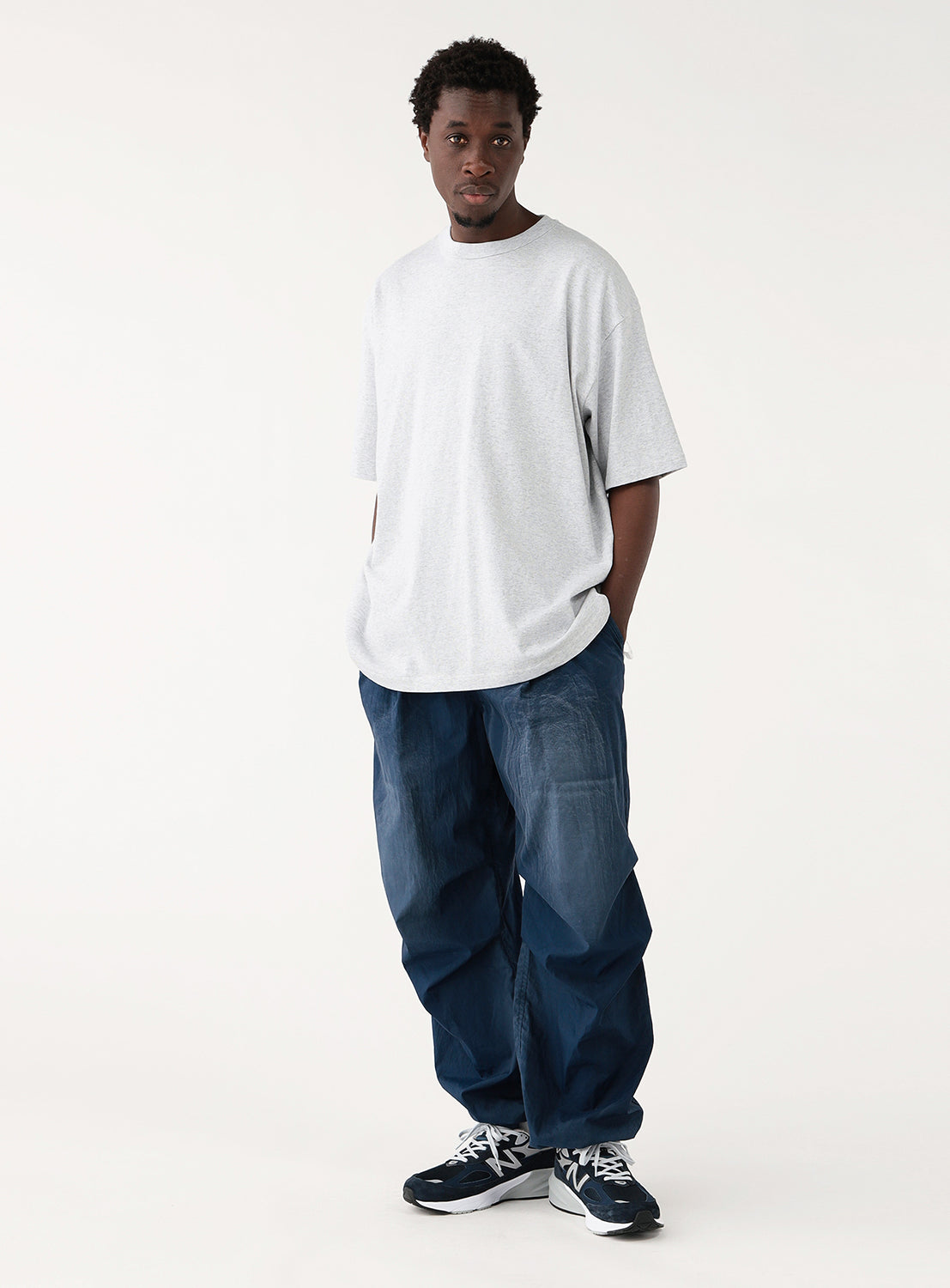 Full view of styling the ash grey comfortable t-shirt styled with blue relaxed fit jeans. 