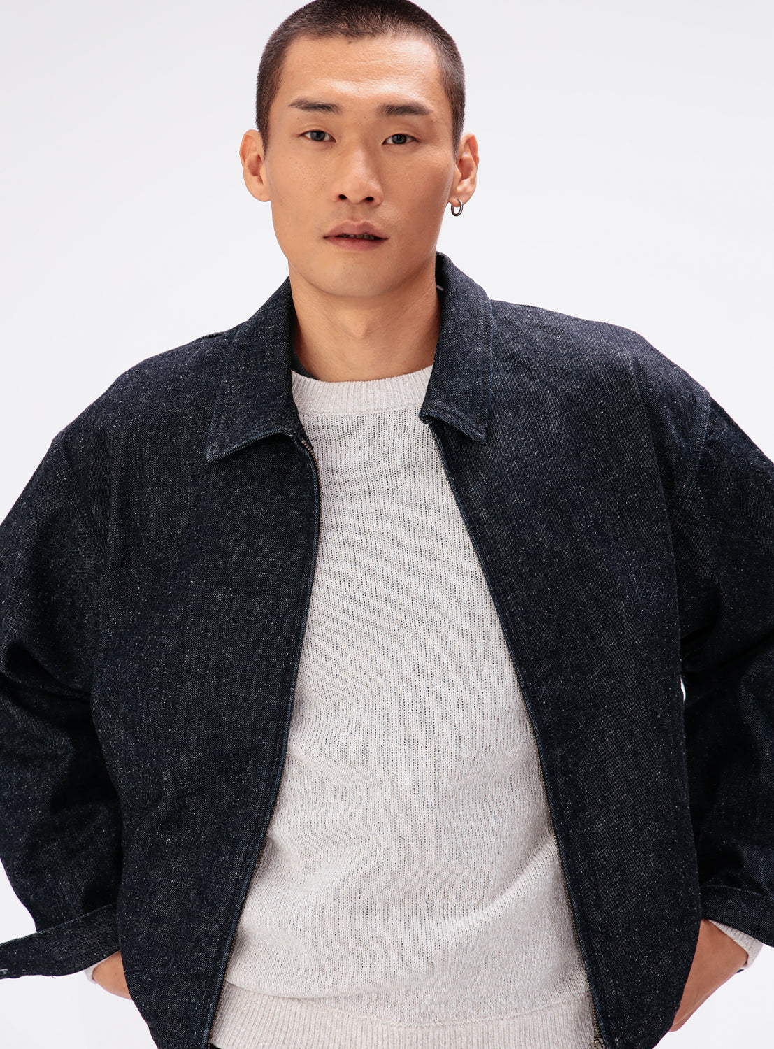 A model wears an unzipped vintage-inspired dark denim BEAMS Nep Denim Zip Jacket over a white crewneck sweater.