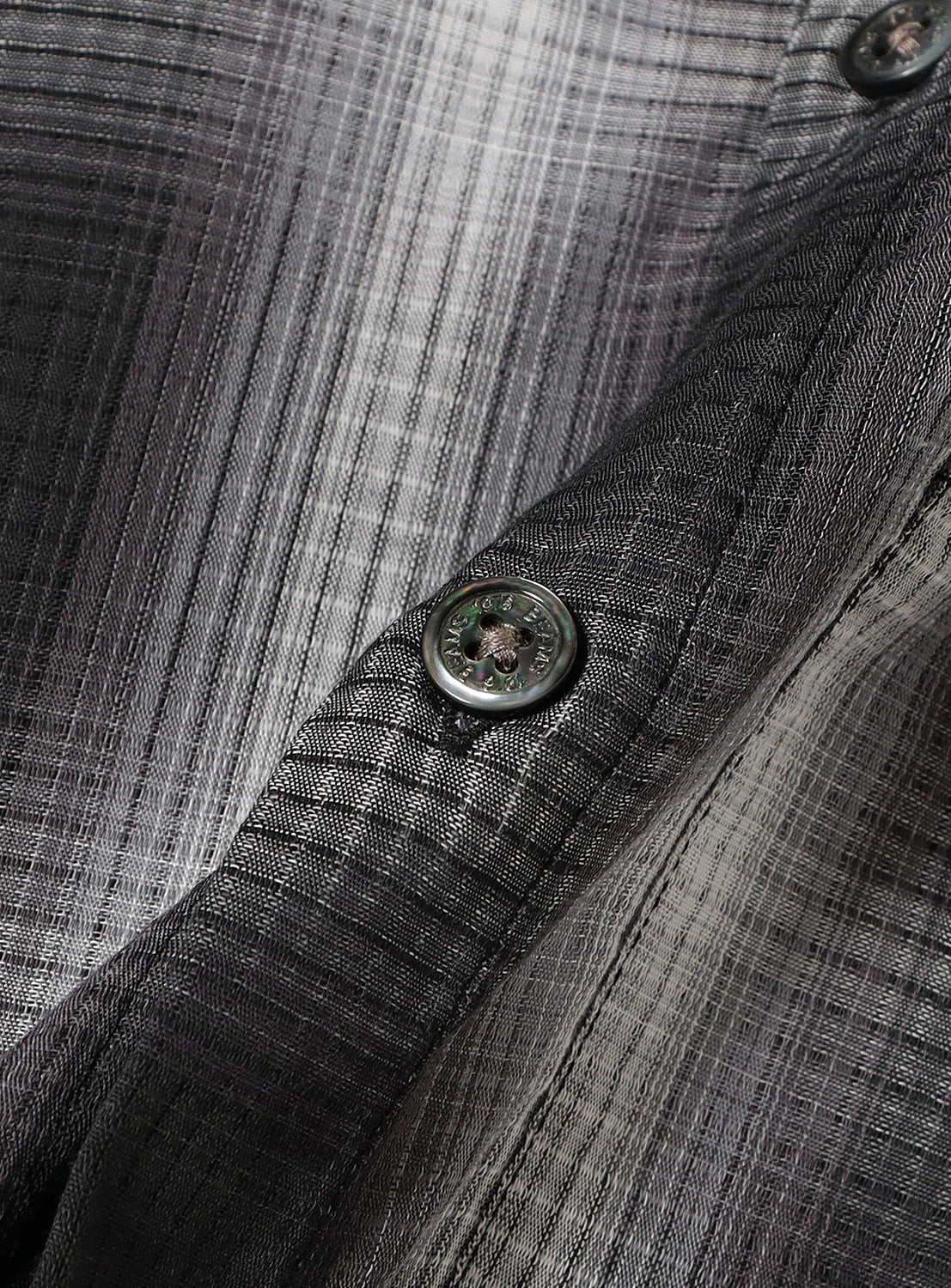 Close-up of a button on a plaid fabric.
